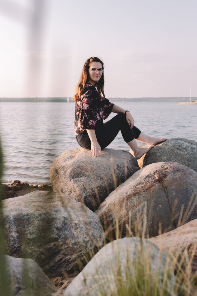 Frau sitzt auf Steinen und blickt in die Kamera - Personal Branding Fotografie