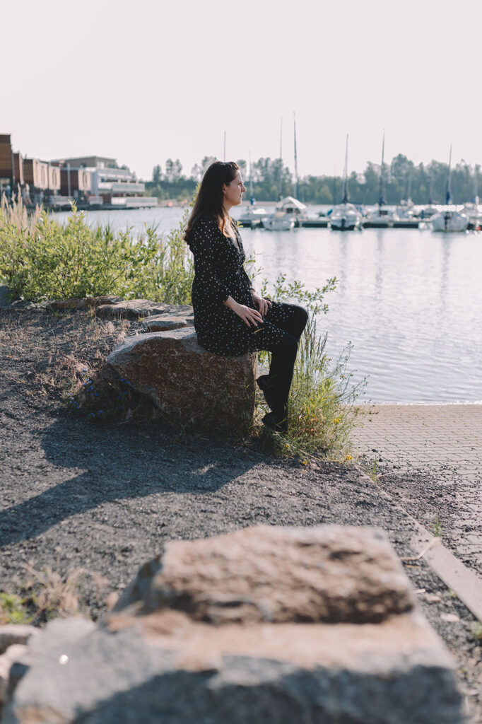 Frau sitzt auf Stein am See - Personal Branding Fotografie